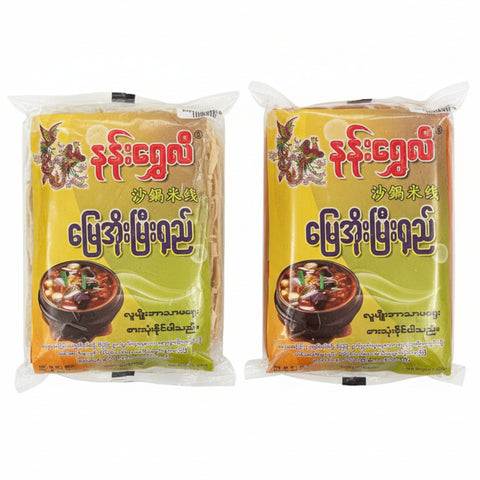 Two packages of instant noodles with a clear plastic wrap on a wooden surface.