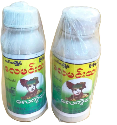 Two plastic bottles of a white powder wrapped in clear plastic, featuring yellow and green labels with red text and a cartoon illustration, set against a beige background with a 'KABAR SHOP' logo in the top-left corner.